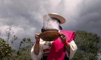 Ecuador. A member of the Ancestral Women's Committee, holds a fire during a ceremony to give thanks for the harvest at Cuicocha Lagoon. Photo: FAO/Johanna Alarcón