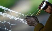 A fisherman mending his net. © FAO/Jose Cendon