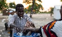 Children play with water from a recently installed water well in a poor village in Northeast of Mozambique. Shutterstock/JonathanJones