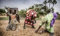 A woman planting seeds. © FAO/Luis Tato