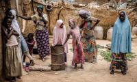 A group of women and girls gather at the entrance of their house. © FAO/Luis Tato