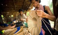 A weaver making a hat from dried reeds. Hats. FAO