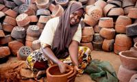 A young woman making pottery in a small factory. File swm